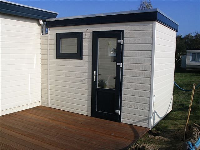 Windscherm en berging bij een caravan